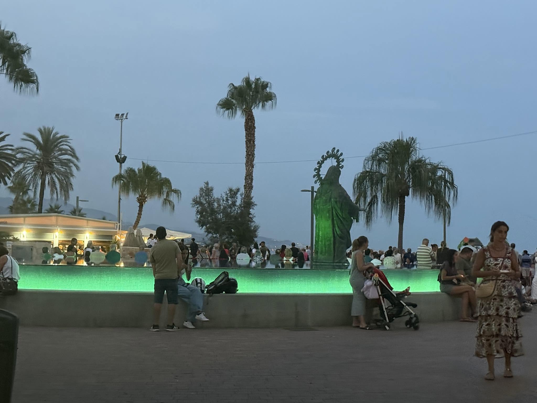 Fuente de la Virgen del Carmen de Torre del Mar iluminada de verde por el Día de la Lesión Medular